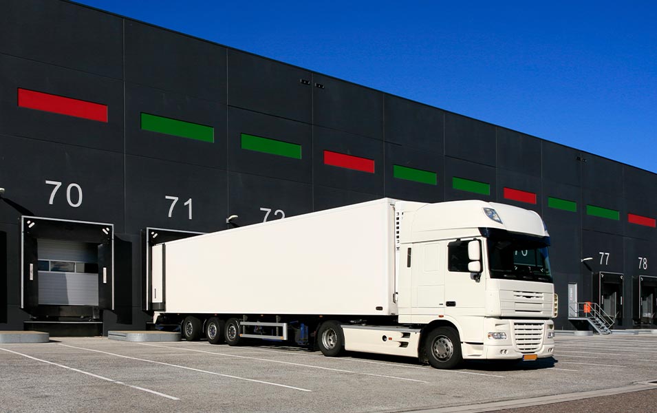 weißer Lkw vor einer Garage